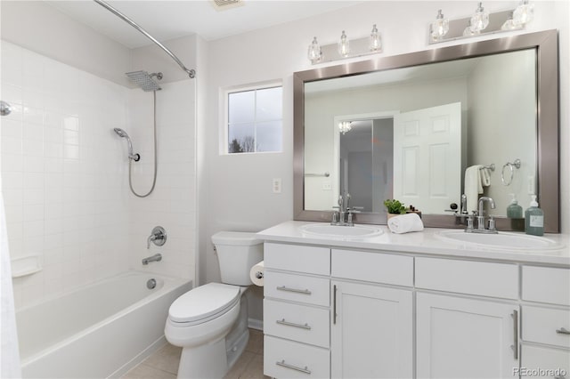 bathroom with double vanity, a sink, toilet, and tile patterned floors