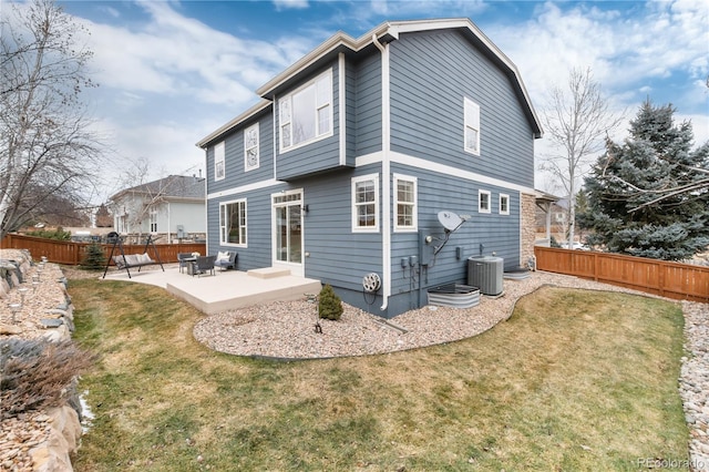 back of property with central AC, fence, a lawn, and a patio