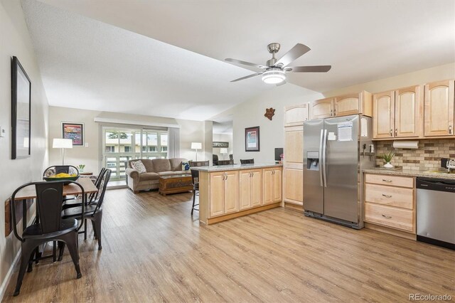 9625 E Center Ave Unit 5D, Denver, CO 80247 - kitchen featuring light brown cabinetry, stainless steel appliances, open floor plan, light wood-style flooring, and a peninsula