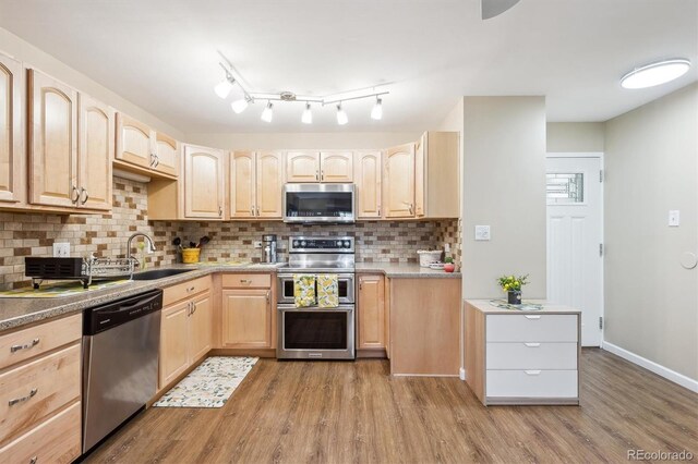 9625 E Center Ave Unit 5D, Denver, CO 80247 - kitchen featuring stainless steel appliances, light brown cabinetry, a sink, wood finished floors, and decorative backsplash