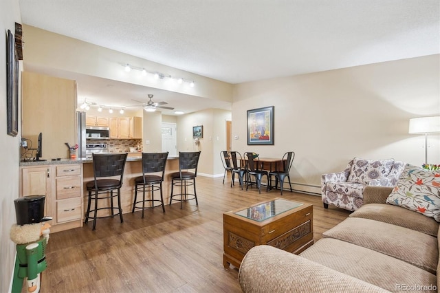 9625 E Center Ave Unit 5D, Denver, CO 80247 - living area with wood finished floors, baseboards, and a ceiling fan