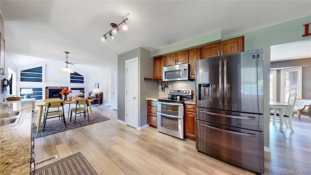 982 E 130th Cir, Thornton, CO 80241 - kitchen with stainless steel appliances, brown cabinetry, light countertops, and light wood-style floors