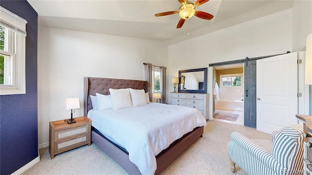 982 E 130th Cir, Thornton, CO 80241 - bedroom featuring light colored carpet, a barn door, ensuite bath, and a ceiling fan