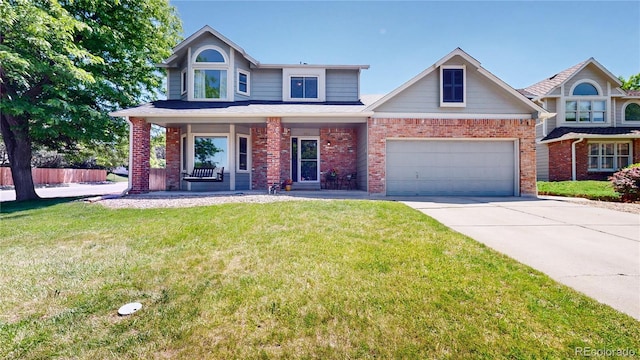 982 E 130th Cir, Thornton, CO 80241 - view of front facade with brick siding, a porch, driveway, a front yard, and an attached garage