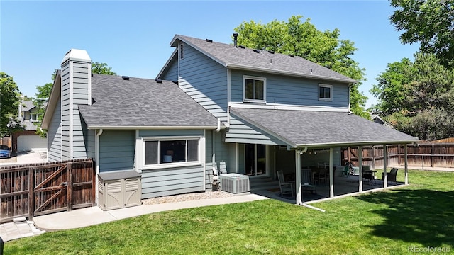 982 E 130th Cir, Thornton, CO 80241 - rear view of house with a shingled roof, a patio area, a fenced backyard, and a chimney