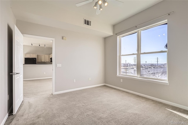 carpeted spare room with ceiling fan