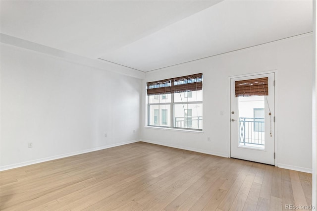 empty room featuring a wealth of natural light and light wood-type flooring