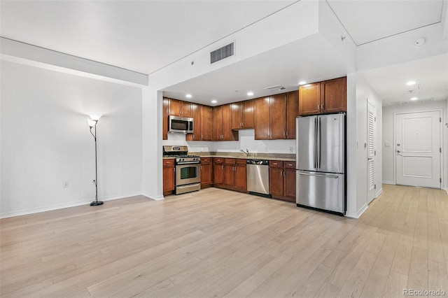 kitchen with stainless steel appliances, sink, and light wood-type flooring