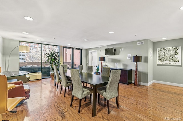 dining area with expansive windows and light hardwood / wood-style floors