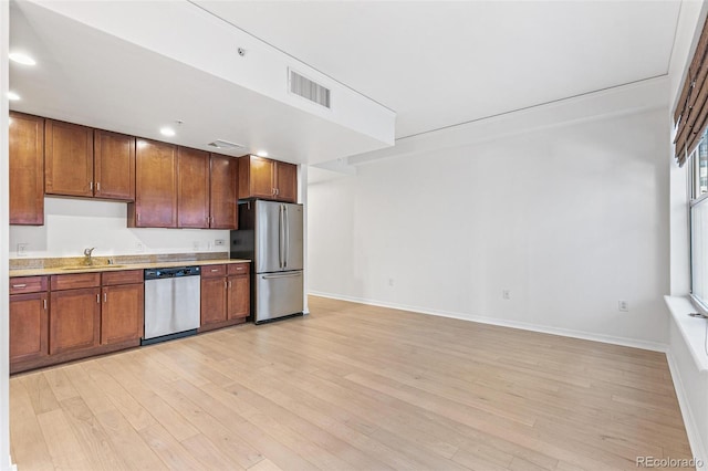 kitchen featuring appliances with stainless steel finishes, sink, and light hardwood / wood-style floors