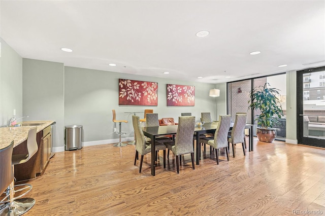 dining space with sink and light hardwood / wood-style floors