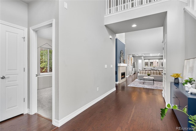 hallway featuring dark wood-type flooring and a high ceiling