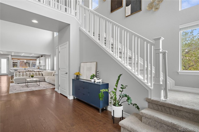 stairs with a high ceiling and hardwood / wood-style floors