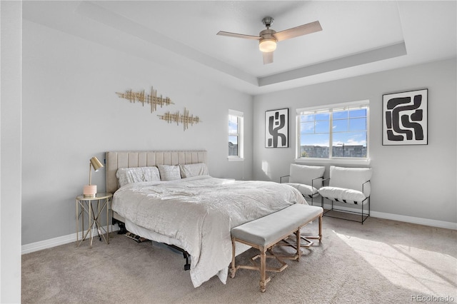 bedroom featuring a raised ceiling, carpet floors, and ceiling fan