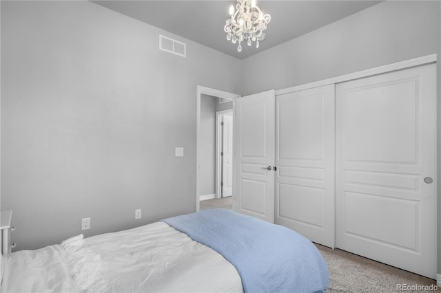 carpeted bedroom with a chandelier and a closet