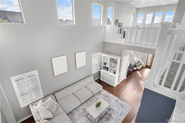 living room with dark hardwood / wood-style floors and a high ceiling