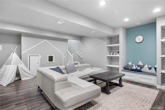 living room featuring dark hardwood / wood-style floors and built in shelves