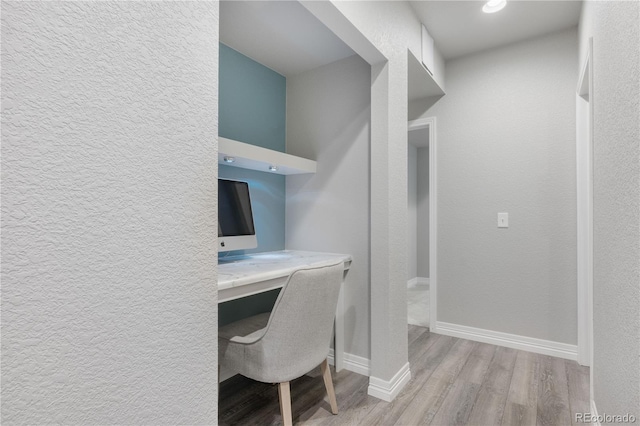 office area featuring built in desk and light wood-type flooring