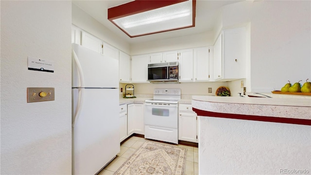 kitchen featuring white cabinetry, light tile patterned flooring, and white appliances