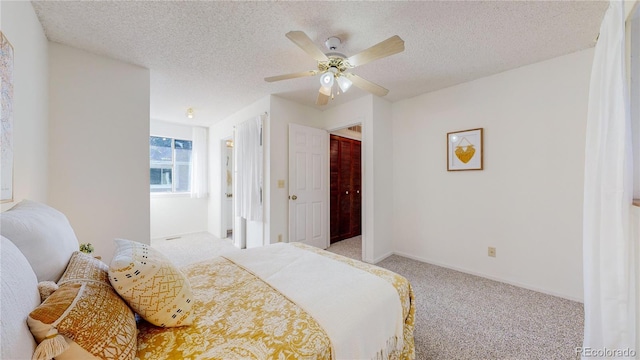 carpeted bedroom with a textured ceiling and ceiling fan