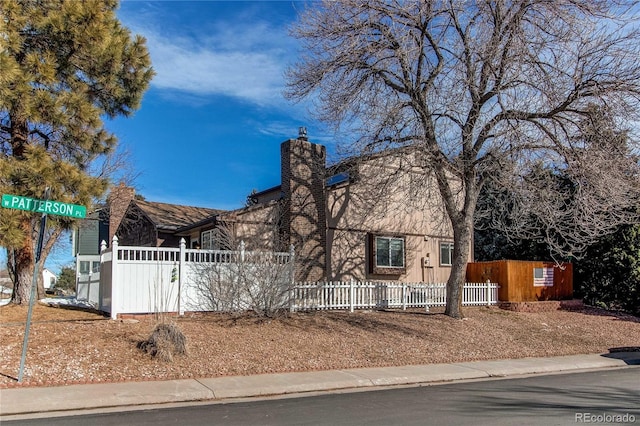 view of front of home with a fenced front yard and a chimney