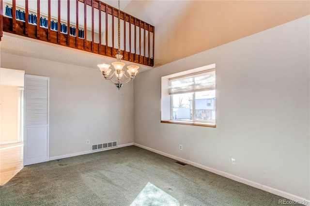 spare room with carpet, visible vents, a chandelier, and baseboards