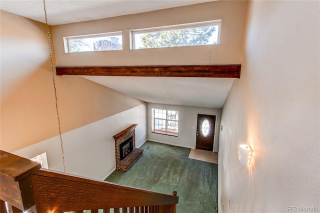 carpeted living room with a fireplace, baseboards, and beam ceiling