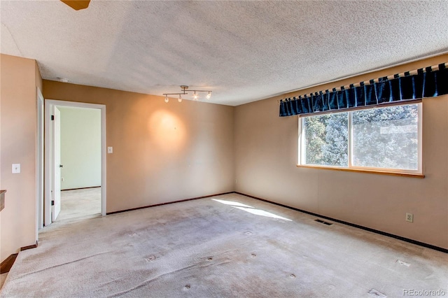 empty room featuring baseboards, a textured ceiling, visible vents, and carpet flooring