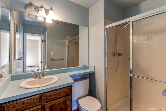 full bath with vanity, a shower stall, and toilet