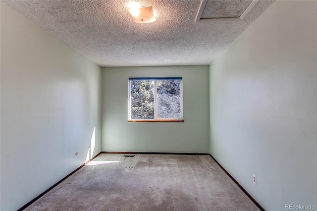 carpeted empty room with a textured ceiling and baseboards