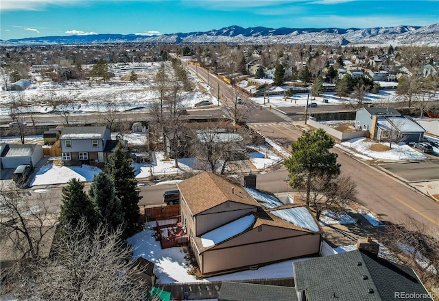 snowy aerial view featuring a residential view and a mountain view