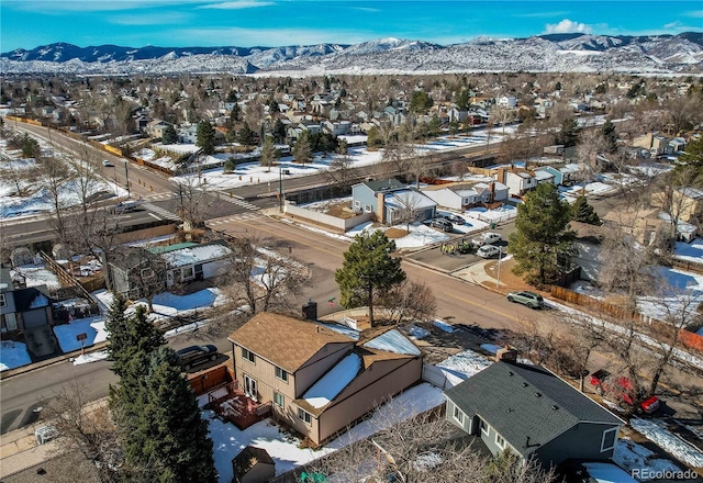 snowy aerial view with a residential view and a mountain view