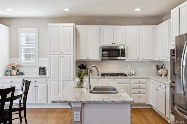 kitchen featuring appliances with stainless steel finishes, white cabinets, and a sink