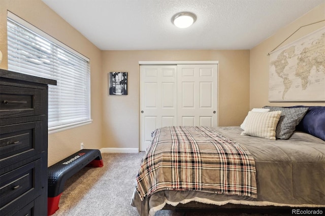 bedroom featuring carpet floors, a textured ceiling, baseboards, and a closet