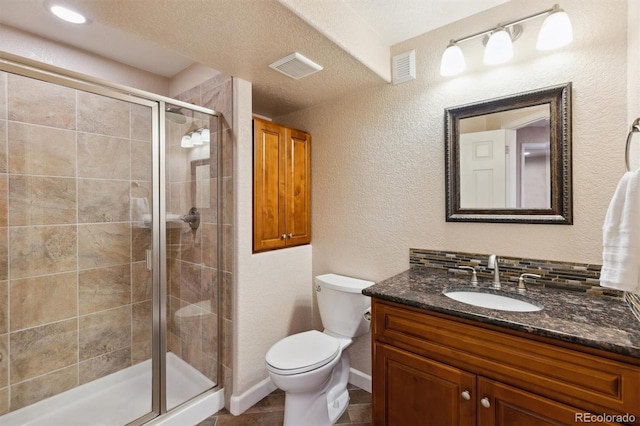 full bath featuring visible vents, toilet, a stall shower, vanity, and a textured ceiling