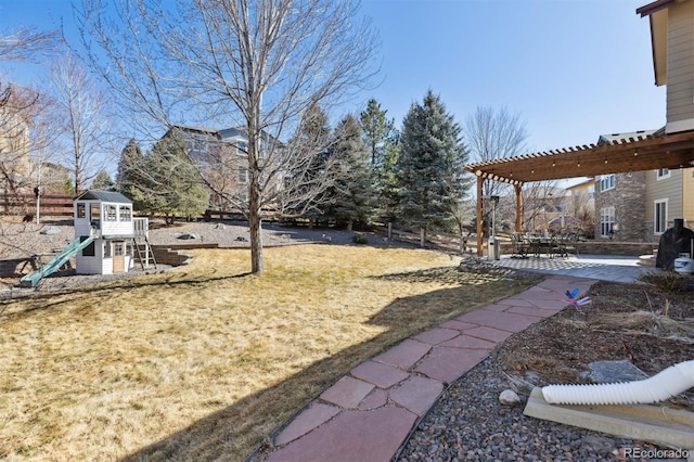 view of yard featuring a patio area, a playground, and a pergola