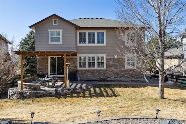 rear view of house featuring stone siding, a yard, a patio area, and a pergola