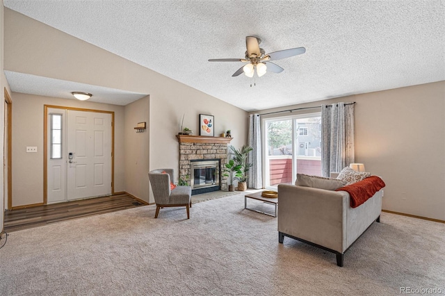 8424 Everett Way Unit A, Arvada, CO 80005 - carpeted living room with a ceiling fan, a textured ceiling, a fireplace, vaulted ceiling, and baseboards