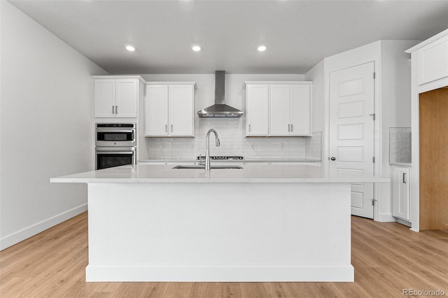 16975 W 92nd Loop, Arvada, CO 80007 - kitchen featuring wall chimney range hood, double oven, light countertops, an island with sink, and recessed lighting