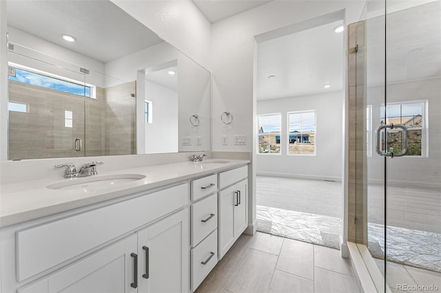 16975 W 92nd Loop, Arvada, CO 80007 - bathroom with double vanity, a stall shower, recessed lighting, tile patterned floors, and baseboards