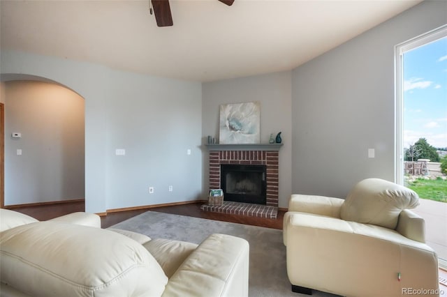 4197 Purple Plum Way, Colorado Springs, CO 80920 - living area featuring arched walkways, ceiling fan, and a brick fireplace