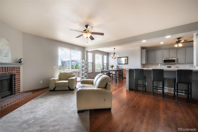 4197 Purple Plum Way, Colorado Springs, CO 80920 - living room with ceiling fan, recessed lighting, a fireplace, dark wood-style flooring, and a chandelier