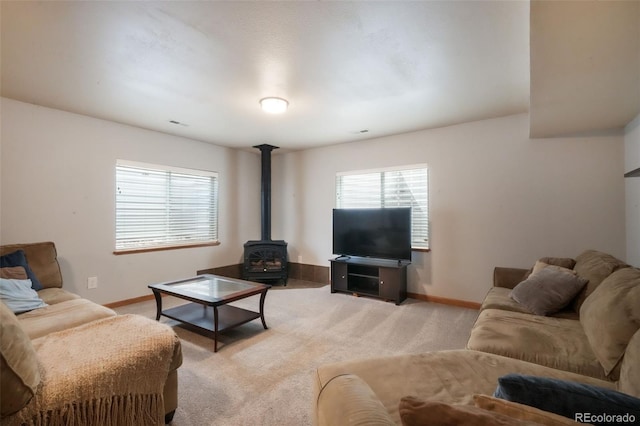 4197 Purple Plum Way, Colorado Springs, CO 80920 - living room featuring a wood stove, baseboards, and light colored carpet
