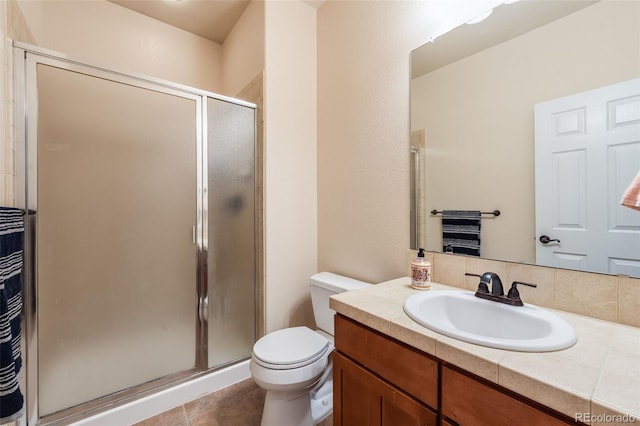 bathroom with a shower stall, toilet, tile patterned flooring, and vanity