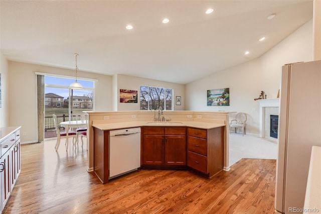 kitchen with white appliances, lofted ceiling, light countertops, and a sink