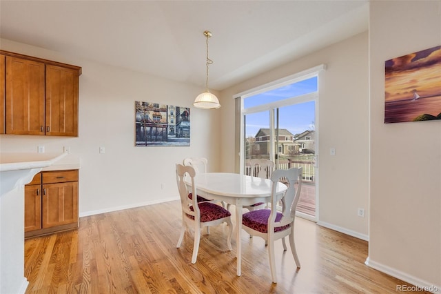 dining space with light wood-style flooring and baseboards