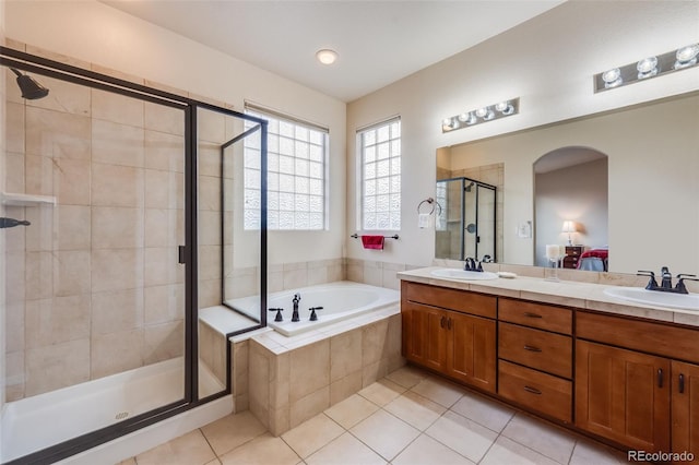 bathroom with double vanity, a sink, a shower stall, and a bath