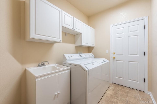 laundry area featuring light tile patterned floors, cabinet space, and washing machine and dryer