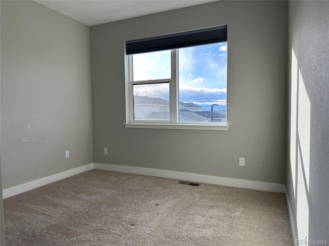 carpeted spare room featuring a mountain view