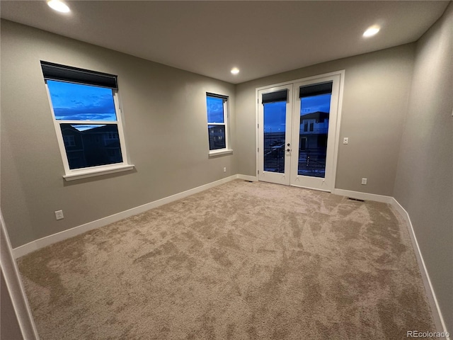 carpeted empty room featuring french doors